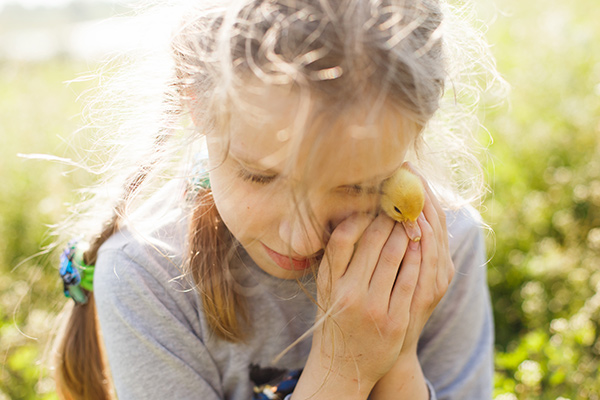 a girl holding a duckling