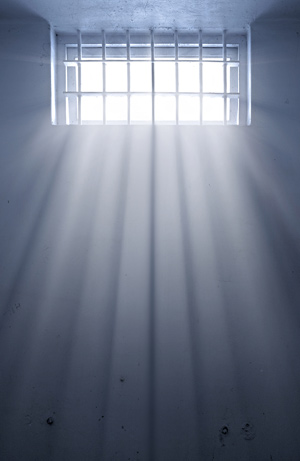 sunlight shining through the bars of a cold jail cell