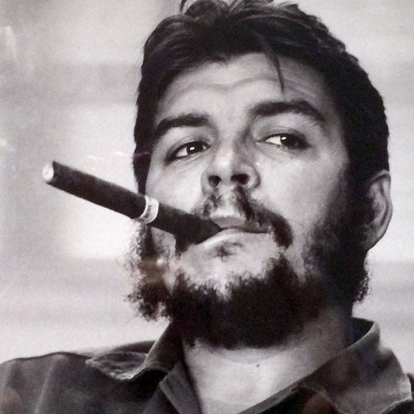 A portrait image of Che Guevara smoking a cigar.