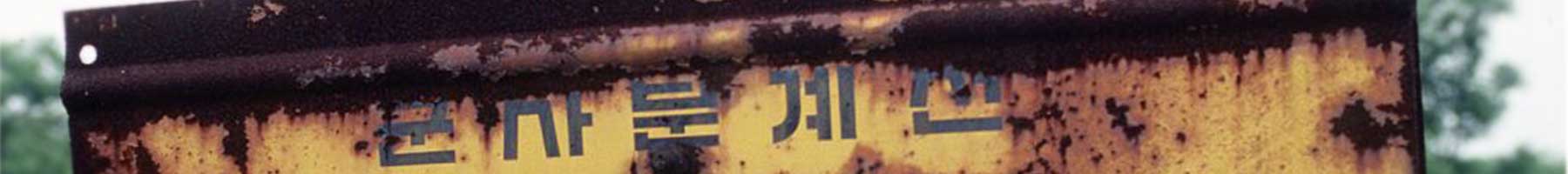 a rusted sign with Korean writing