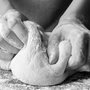 black and white photo of hands kneading bread dough