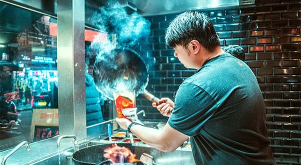 a man cooking food in a wok