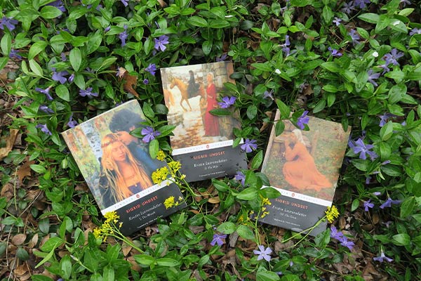 three volumes of Sigrid Undset’s Kristin Lavransdatter among blooming periwinkle