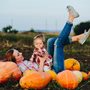 blissful mommy holding toddler in pumpkin patch