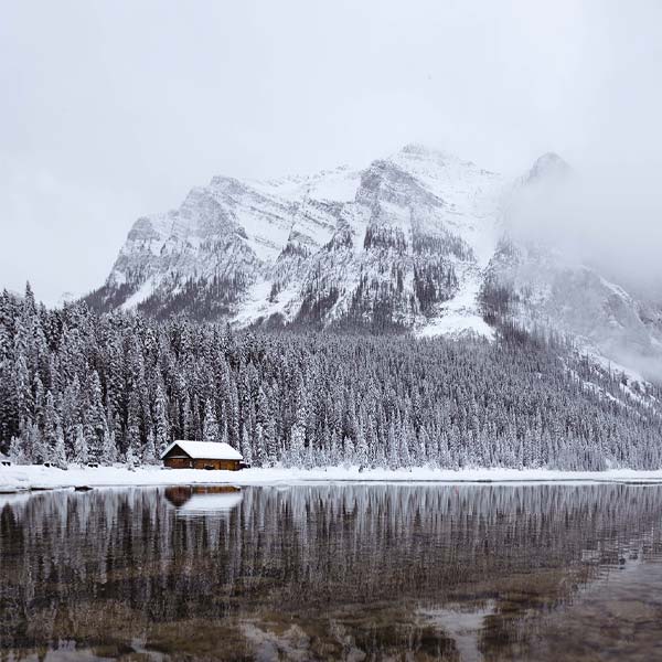 cabin near a mountain lake in winter