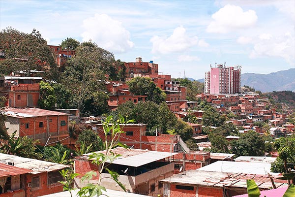 Photograph of unfinished red brick, flat roofed houses on a hillside