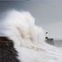 huge wave washing over a lighthouse