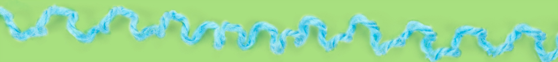 unravelling blue knitting on green background