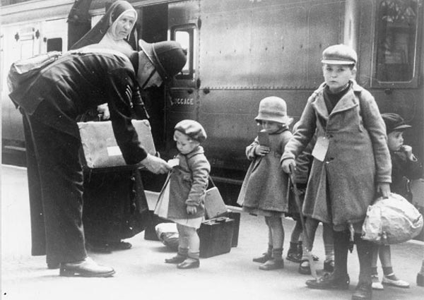 A policeman helps some young evacuees at a London station.