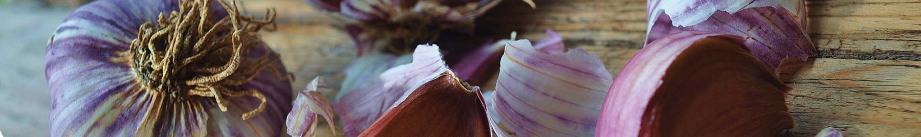Purple onions on a wooden cutting board.