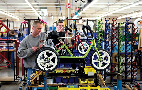 two men building a green Rifton trike