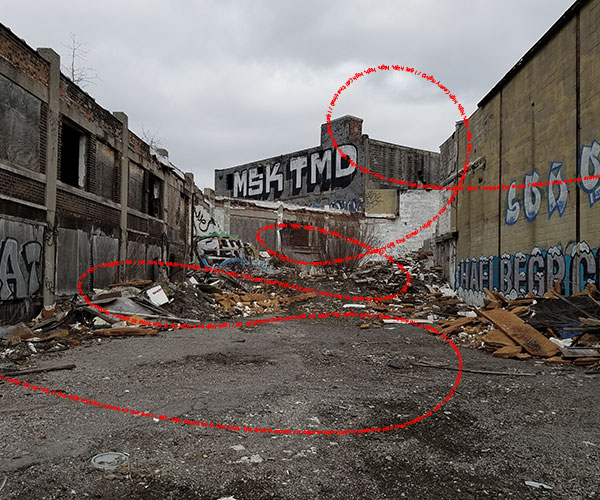 photo of a rubble filled alley with red text of a rap song overlaid