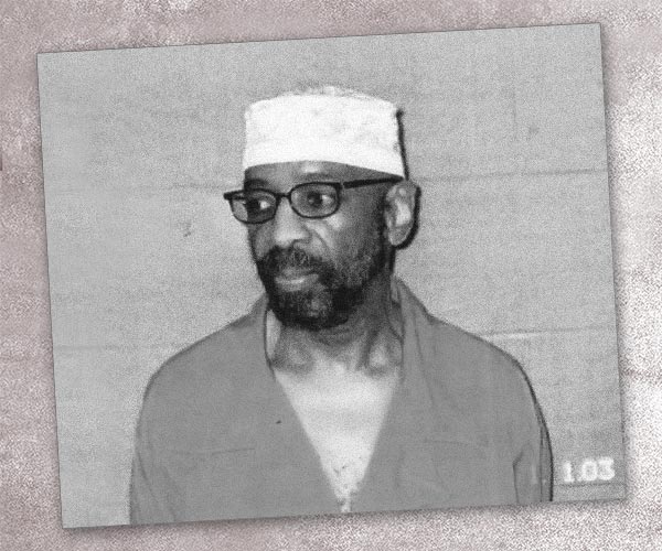 photo of Russell Maroon Shoatz in prison clothes against a cinderblock wall