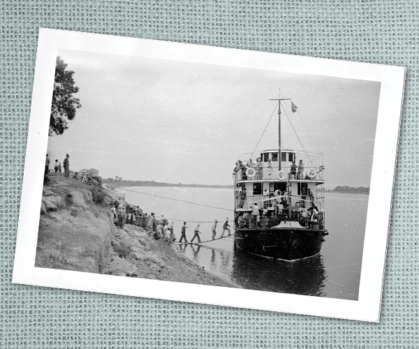 a line of people boarding a steamboat for the inland journey