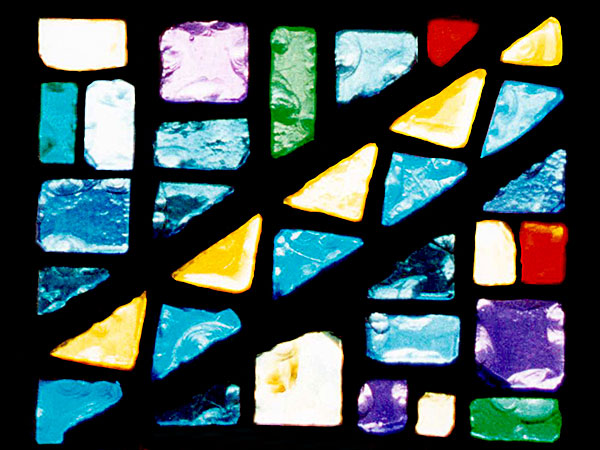 stained glass panel with blocks of blue, yellow, green, purple, and red glass