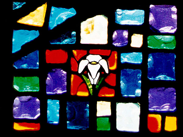 stained glass panel with blocks of blue, yellow, and red glass forming a lily