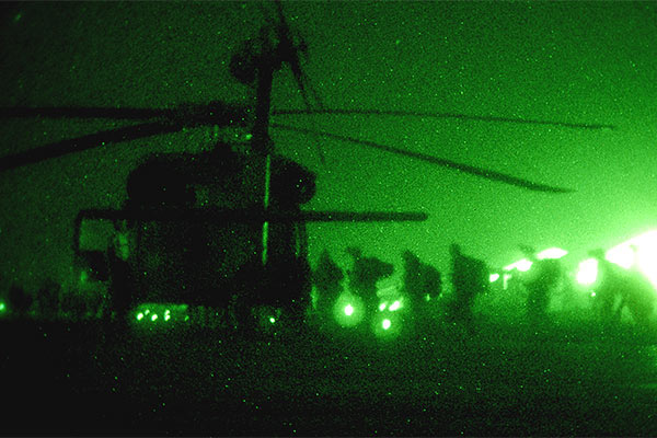 green tinged photograph taken through night vision goggles of US Marines boarding a helicopter