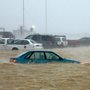 blue car half submerged in flood waters