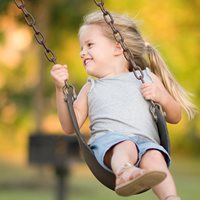 a little blond girl on a swing
