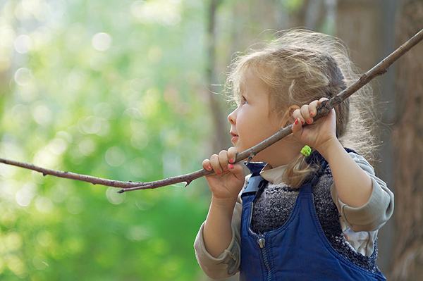 a young girl holding a branch of a tree