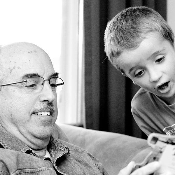 an old man and a boy looking at a book