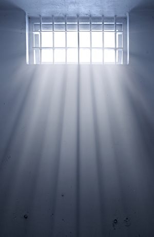sunlight shining through the bars of a cold jail cell