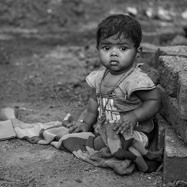 black and white photo of a young girl sitting on the ground
