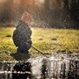 a kid splashing water with a stick