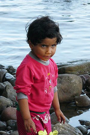 Child in pink shirt comes ashore on the island of Lesbos, Greece.