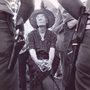 Dorothy Day, seated in front of two police officers