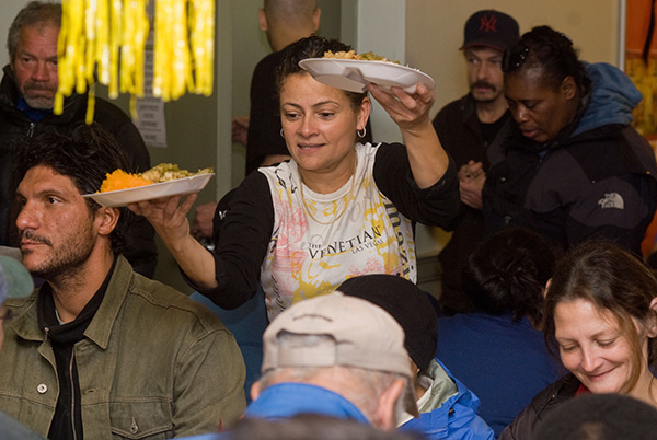 a woman serving Thanksgiving dinners at a soup kitchen