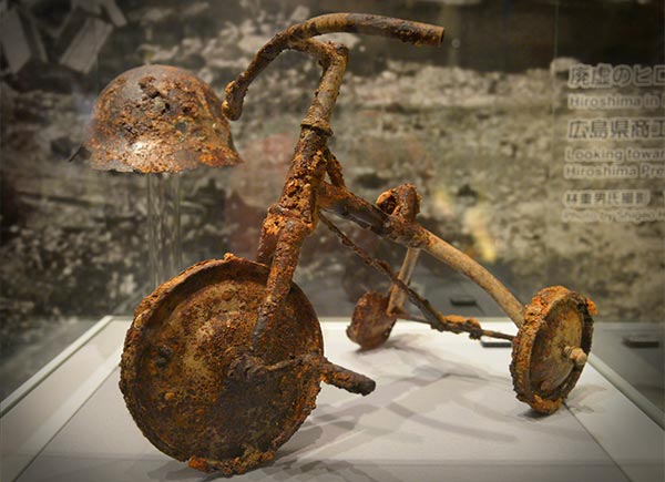 a childs rusted trike damaged by the atom bomb dropped on Hiroshima