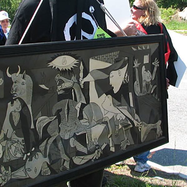 An antiwar protester wearing a poster of Pablo Picasso's famous antiwar painting, Guernica.