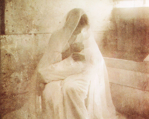 a mother holding a baby in a barn