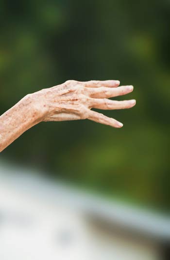 An elderly hospice patient reaches out