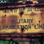 a rusted sign with Korean and English writing