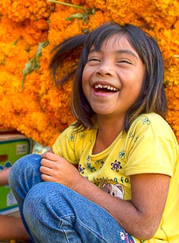 Laughing mexican children with a background of orange marigolds