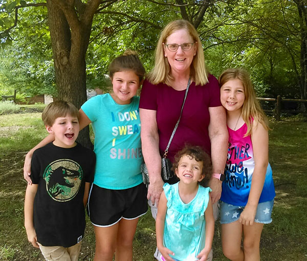 a middle-aged woman surrounded by four children