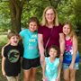 a middle-aged woman surrounded by four children