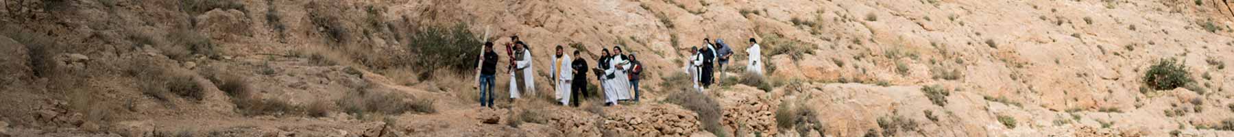 a procession of people on an arid mountainside
