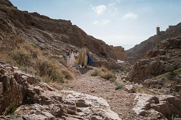 Father Jihad leads the Palm Sunday procession, which begins out in the wadi (valley) and makes its way toward the monastery.
