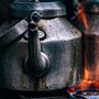 a metal teapot over a gas burner