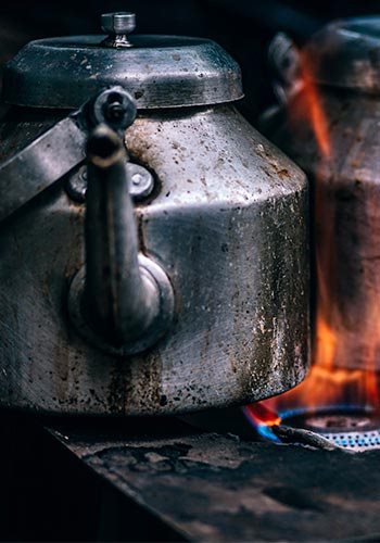 a metal teapot over a gas burner