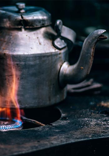 a metal teapot over a gas burner