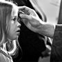 a child receives ashes on her forehead on Ash Wednesday