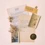 flatlay collage of handwritten and typed poems, an old photo, and hydrangea flowers
