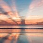 the sun rising behind a cloud