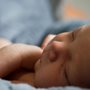 a baby sleeping on a blue blanket