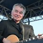 John Prine playing guitar on a stage