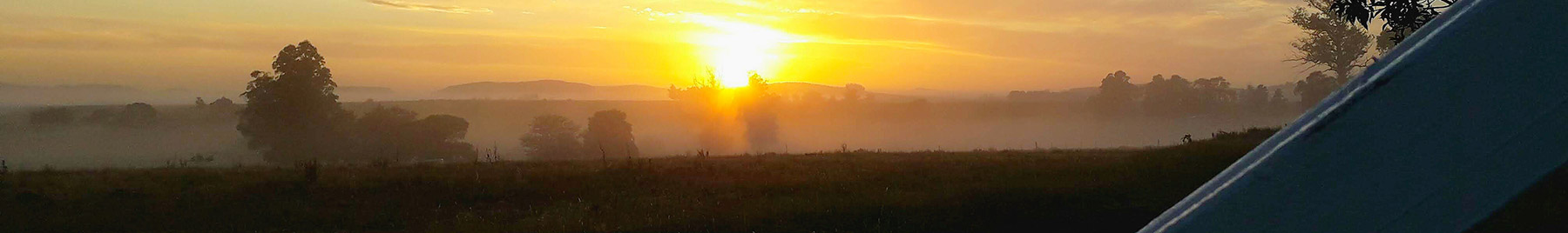 Rural sunset seen through a gate